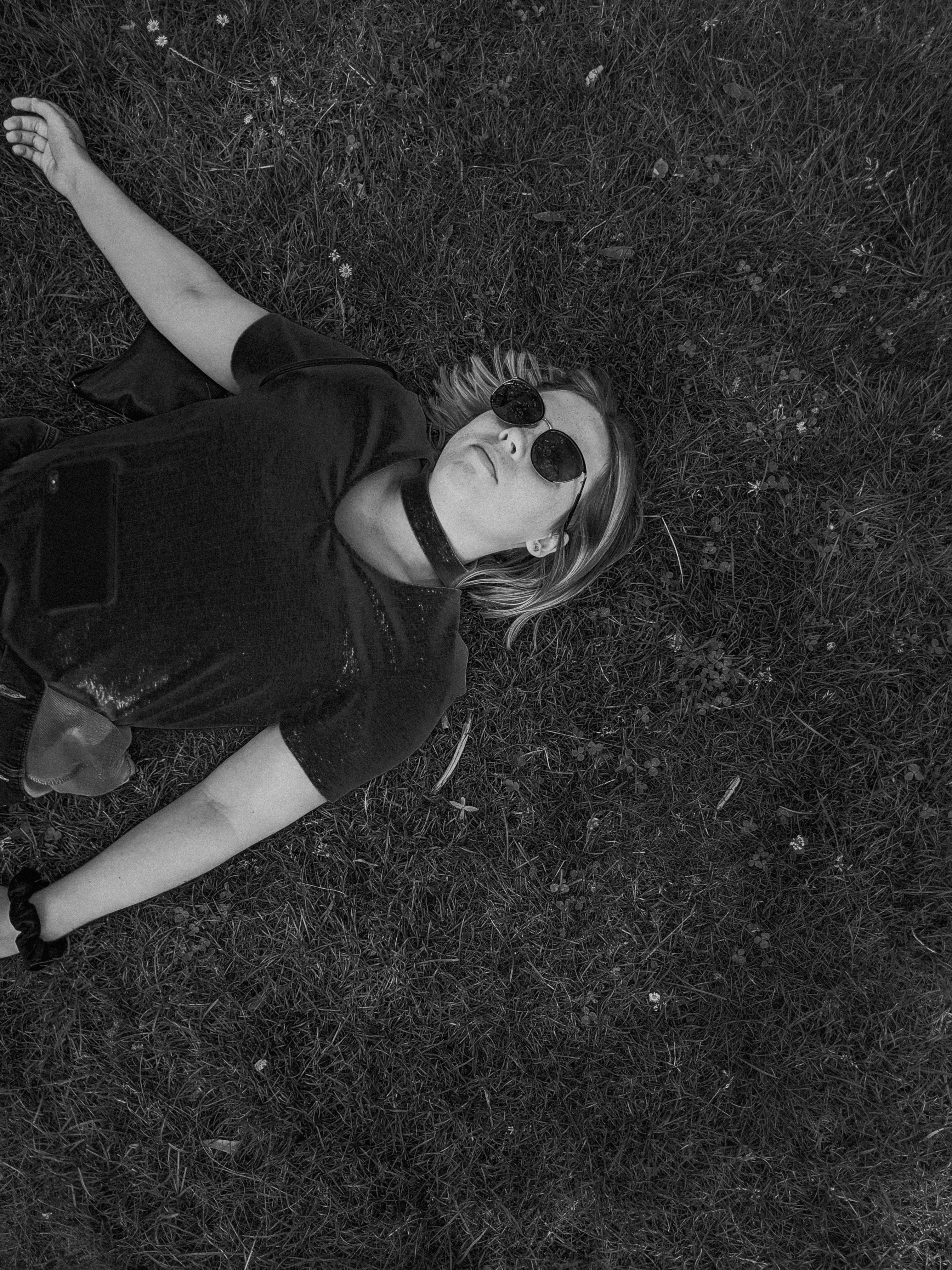 woman in black t-shirt lying on grass field